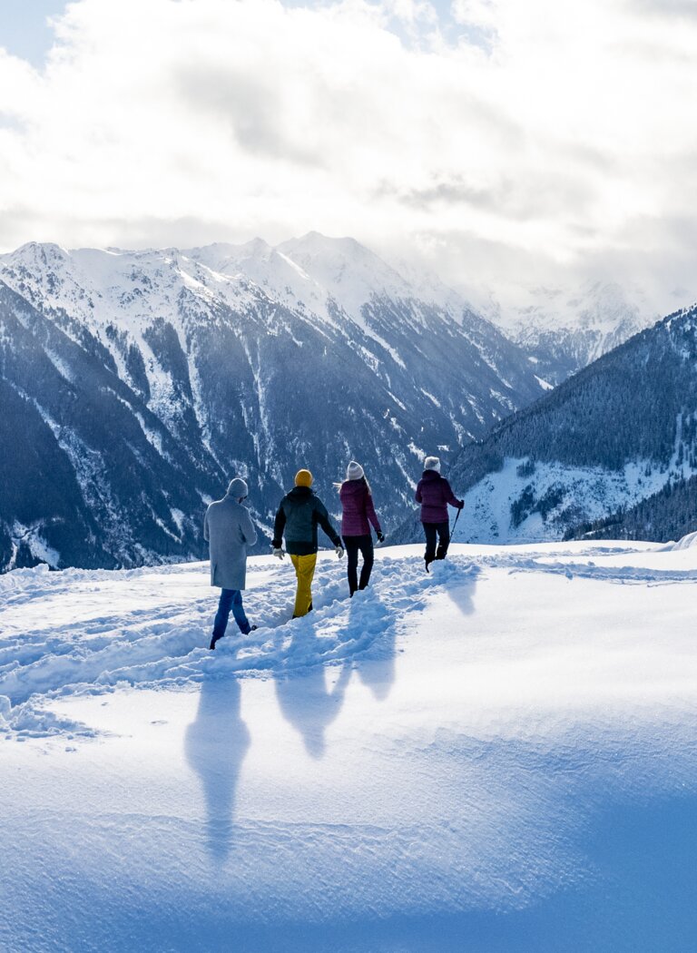 Winterwanderung mit Weitblick über verschneite Alpenlandschaft | © Winterwanderbilder (c) Gerald Oberreiter Vier Personen wandern durch frischen Pulverschnee mit Blick auf verschneite Berggipfel und winterliche Alpenlandschaft. | © Winterwanderbilder (c) Gerald Oberreiter