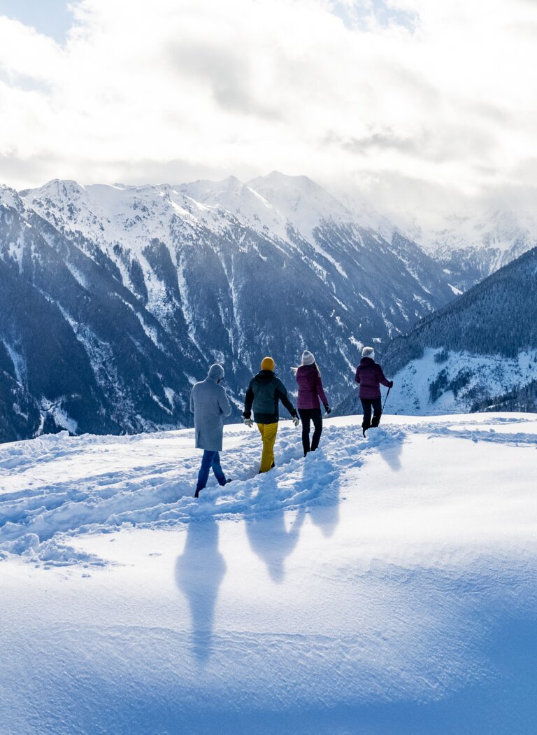 Winter hike with panoramic view over snow-covered alpine landscape | © Winterwanderbilder (c) Gerald Oberreiter Four people hike through fresh powder snow with views of snowy peaks and a wintry alpine landscape. | © Winterwanderbilder (c) Gerald Oberreiter